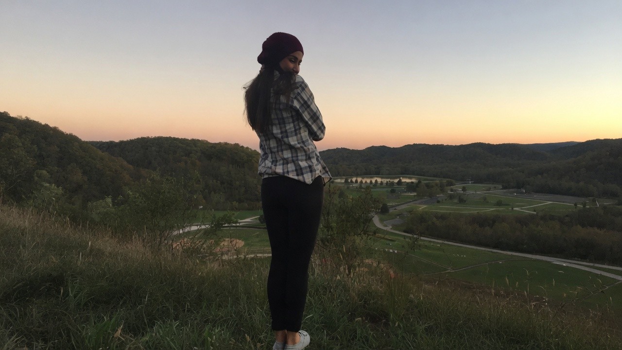 Shannon standing on Overlook Trail at dusk, looking back over Barboursville Park